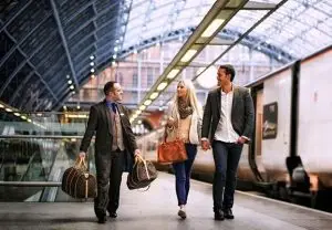 Chauffeur carrying a couple's luggage on the station platform, private transfer to Courchevel